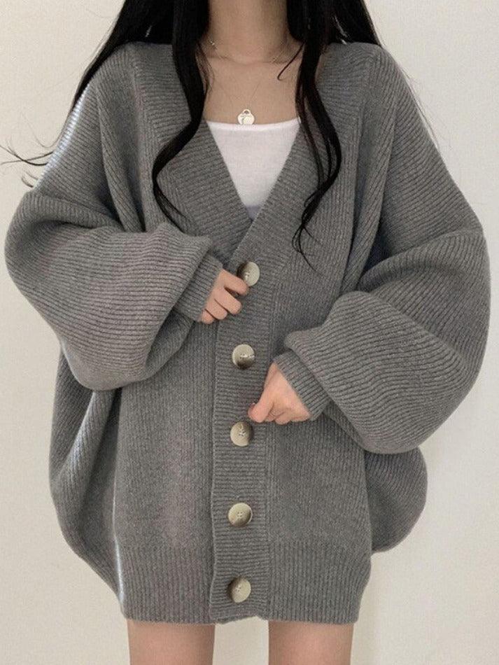 Gray - Women's oversized ribbed knit cardigan featuring a V-neckline, large button closures, and voluminous balloon sleeves with fitted cuffs, styled open over a black top.