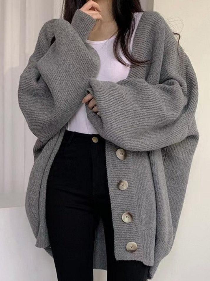 Gray - Women's oversized ribbed knit cardigan featuring a V-neckline, large button closures, and voluminous balloon sleeves with fitted cuffs, styled open over a black top.