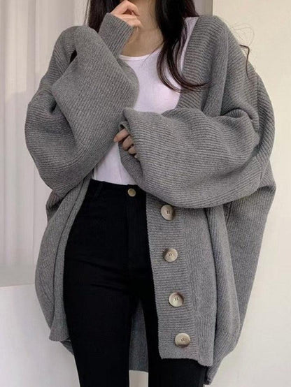 Gray - Women's oversized ribbed knit cardigan featuring a V-neckline, large button closures, and voluminous balloon sleeves with fitted cuffs, styled open over a black top.