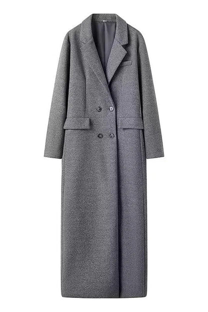 Grey - A woman wearing an oversized, double-breasted maxi coat in textured heather grey wool, featuring wide notched lapels and flap pockets, paired with a matching grey pillbox hat.