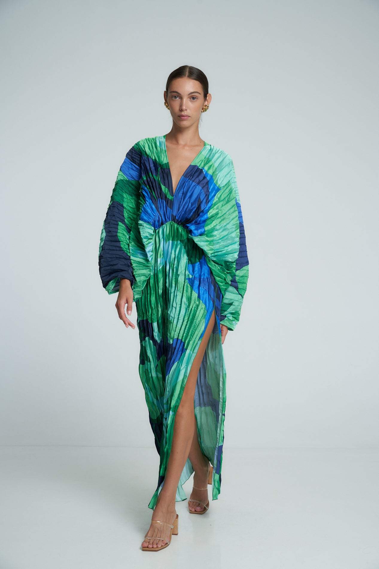 Green - Women's formal maxi dress featuring an all-over micro-pleated texture, bold green and blue abstract print, deep V-neckline, voluminous long sleeves, and a high side slit.