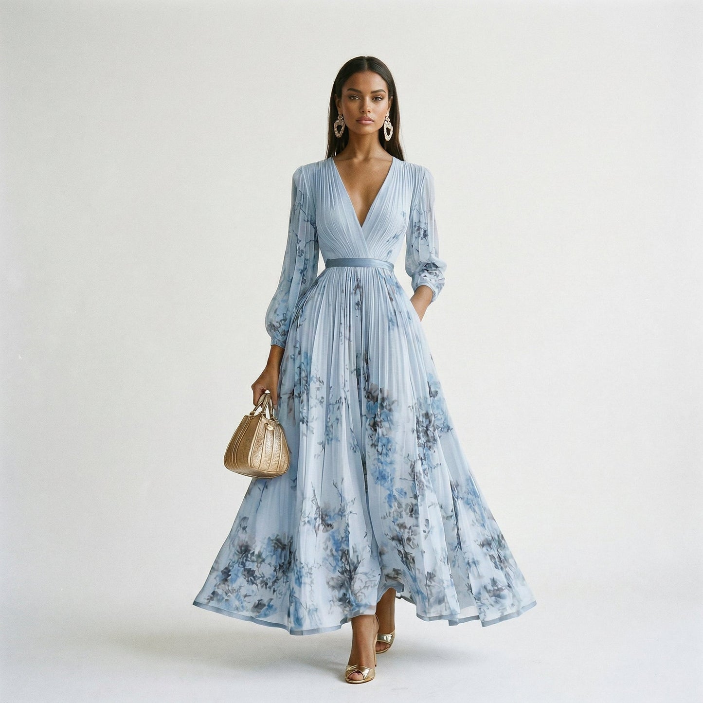 Blue - A woman wearing a pale green long-sleeve maxi dress with a dark green floral motif, featuring a pleated chiffon texture, V-neckline, and a flowing skirt.