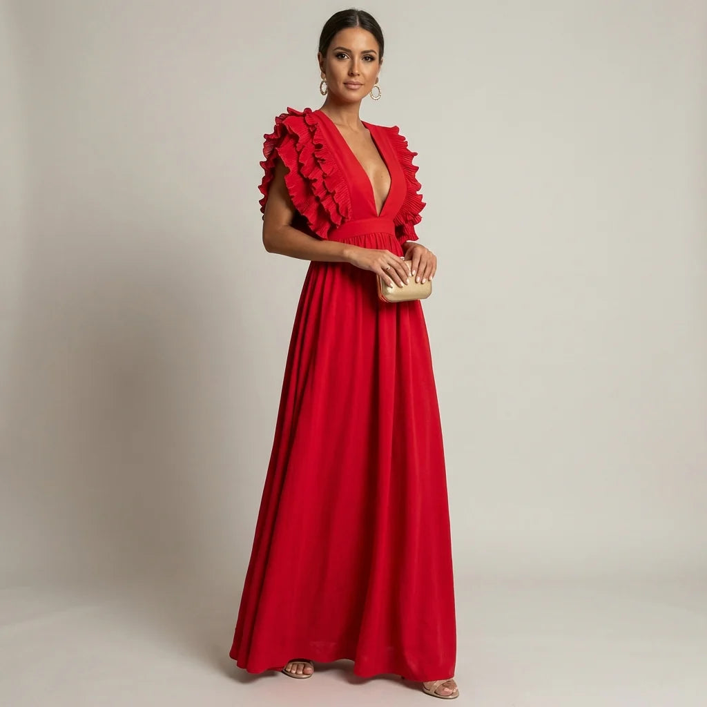 Red - A woman wearing a floor-length cornflower blue maxi dress with a plunging V-neckline and voluminous, finely pleated ruffle sleeves, holding a gold clutch.