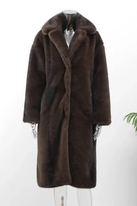 Brown - A woman wearing a luxurious, longline brown faux fur coat with oversized lapels, styled over a white collared shirt.