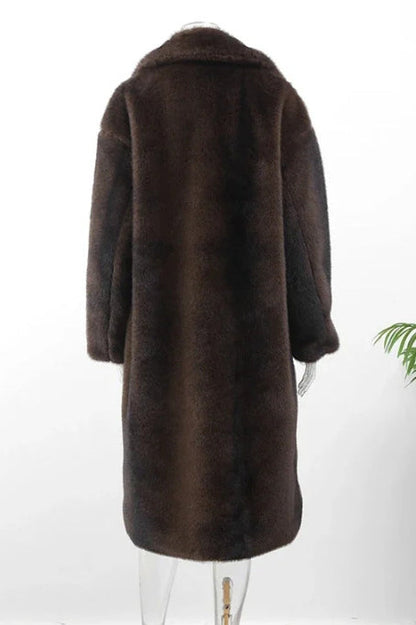 Brown - A woman wearing a luxurious, longline brown faux fur coat with oversized lapels, styled over a white collared shirt.