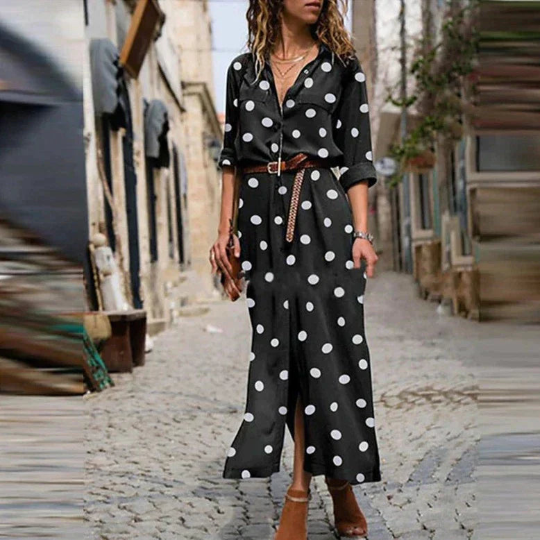 Black - Woman walking outdoors wearing a long polka dot button-front shirt dress with long sleeves and chest pockets