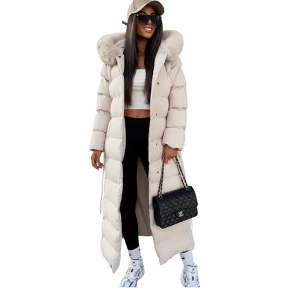 White - A woman wearing a longline black quilted puffer coat with a plush black fur-trimmed hood and a self-tie belted waist, set against a clean white background.