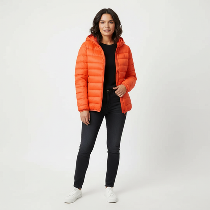 Orange - A woman wearing an off-white hooded puffer jacket with horizontal quilting, zipped up, paired with blue jeans against a plain white background.