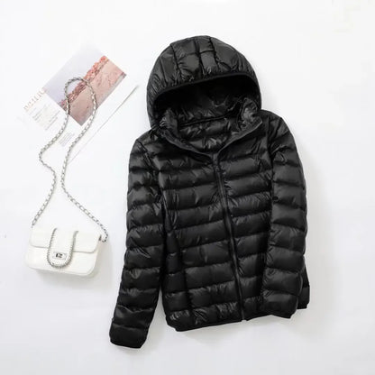 Pink - A woman wearing an off-white hooded puffer jacket with horizontal quilting, zipped up, paired with blue jeans against a plain white background.