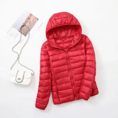 Pink - A woman wearing an off-white hooded puffer jacket with horizontal quilting, zipped up, paired with blue jeans against a plain white background.