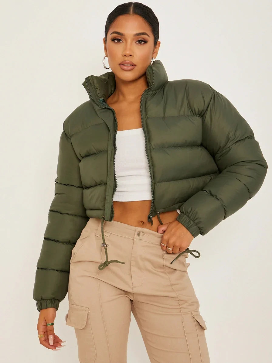 Army Green - A woman wearing a dark brown cropped puffer jacket with an integrated hood, featuring horizontal quilting, a front zip closure, and adjustable drawstring toggles at the hem, paired with black high-waisted jeans.