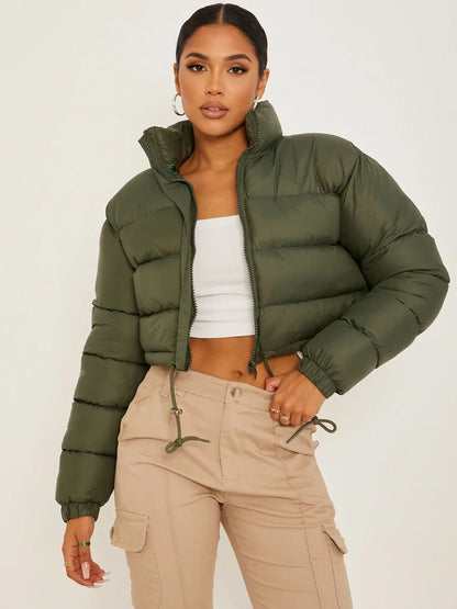 Army Green - A woman wearing a dark brown cropped puffer jacket with an integrated hood, featuring horizontal quilting, a front zip closure, and adjustable drawstring toggles at the hem, paired with black high-waisted jeans.