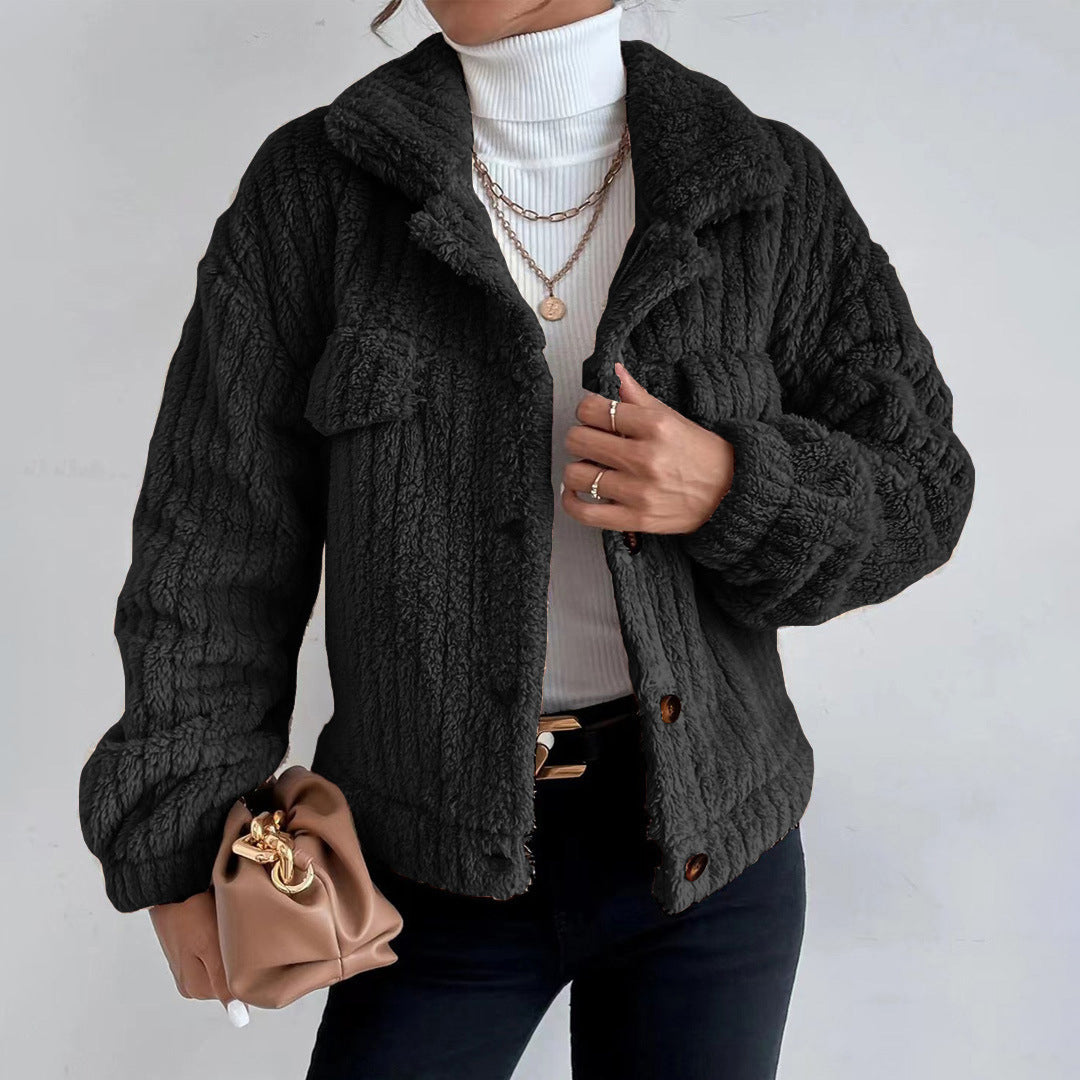 Black - Women's black heavyweight faux shearling jacket featuring a collared neckline, tortoiseshell buttons, dual chest pockets, and a distinct vertical ribbed texture, styled over a white turtleneck.