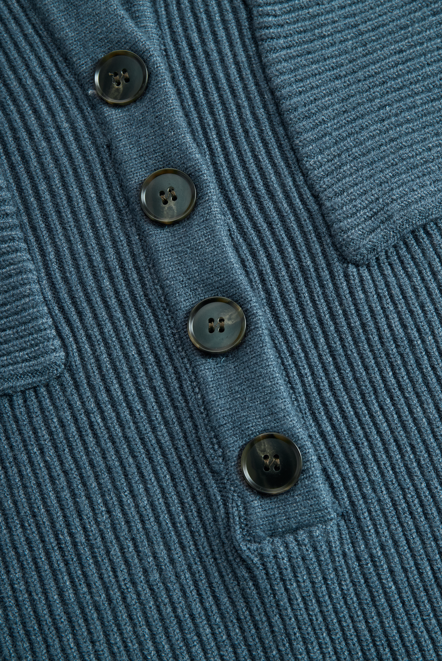 Green - A woman wearing a long-sleeve, blue-grey ribbed knit maxi dress featuring a hood, a button-down neckline, and chest flap pockets, paired with a woven tote bag.