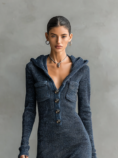 Navy - A woman wearing a long-sleeve, blue-grey ribbed knit maxi dress featuring a hood, a button-down neckline, and chest flap pockets, paired with a woven tote bag.