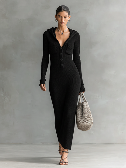 Black - A woman wearing a long-sleeve, blue-grey ribbed knit maxi dress featuring a hood, a button-down neckline, and chest flap pockets, paired with a woven tote bag.
