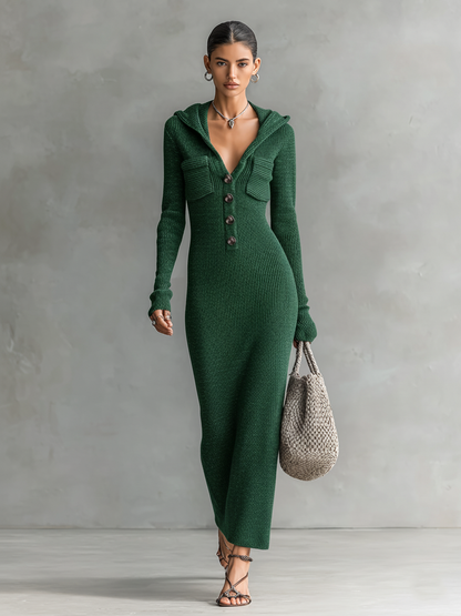 Green - A woman wearing a long-sleeve, blue-grey ribbed knit maxi dress featuring a hood, a button-down neckline, and chest flap pockets, paired with a woven tote bag.