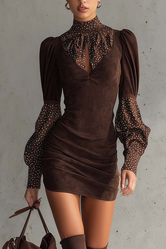 Brown - Woman wearing a fitted ruched mini dress featuring a solid bodice and sheer dotted high neckline and long puff sleeves