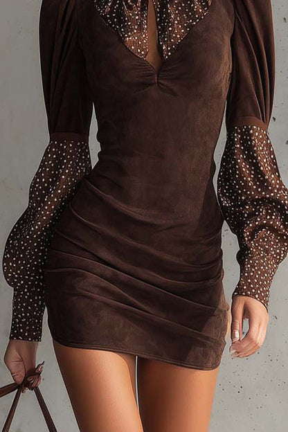 Brown - Woman wearing a fitted ruched mini dress featuring a solid bodice and sheer dotted high neckline and long puff sleeves