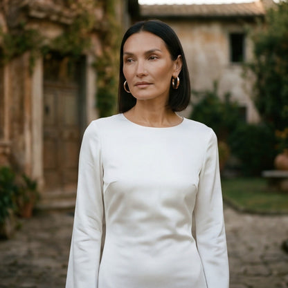 Brown - A woman wearing a long-sleeve chocolate brown satin maxi dress with a round neckline and flared cuffs, standing against a plain white background.