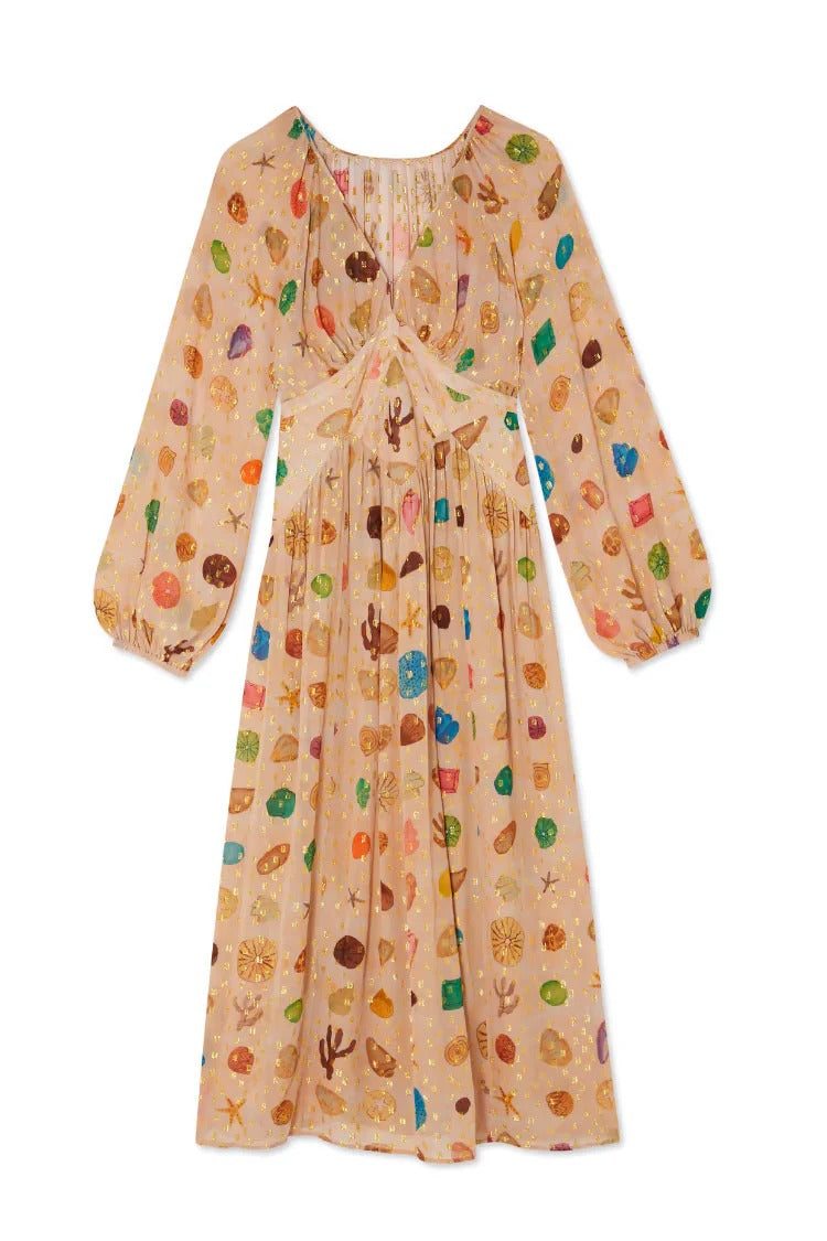 Multicolor - A woman leans against a textured stone wall wearing a peach-coloured maxi dress featuring a multi-coloured seashell motif, gold Lurex flecks, a plunging V-neckline, and long billowy sleeves.