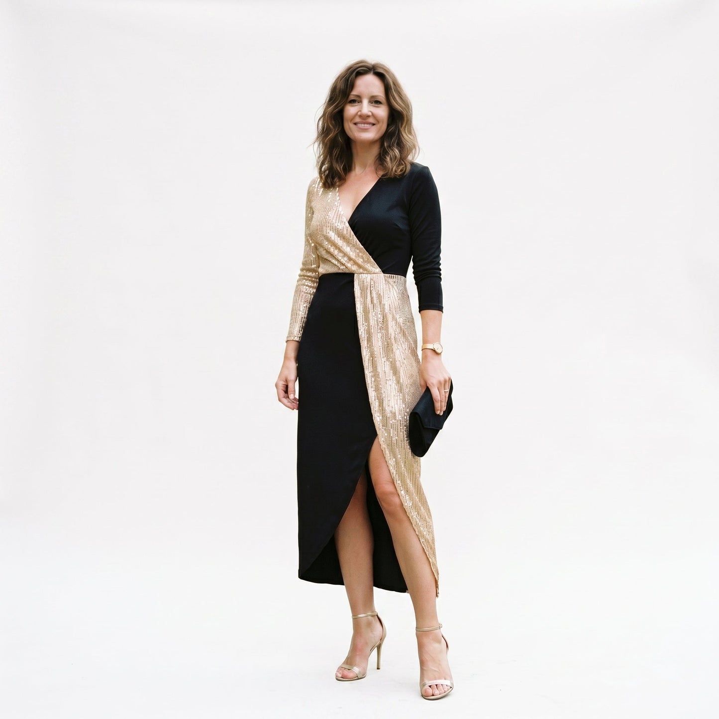2XL(18) - A woman wearing a long-sleeved midi dress featuring a split design with one half in gold sequins and the other half in solid black, styled with black heels against a plain white background.