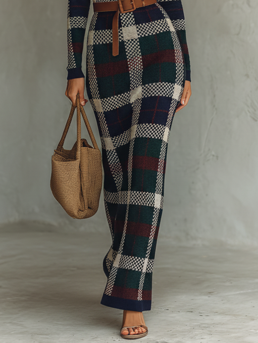 Navy - A woman wearing a long-sleeve, square-neck maxi knit dress featuring a classic navy, green, and white plaid pattern, styled with a brown leather belt at the waist.