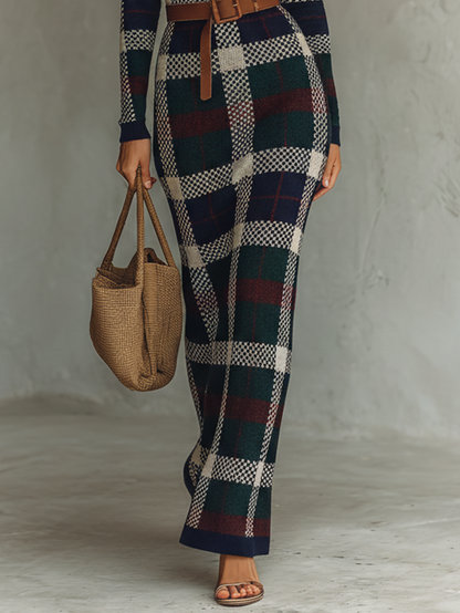 Navy - A woman wearing a long-sleeve, square-neck maxi knit dress featuring a classic navy, green, and white plaid pattern, styled with a brown leather belt at the waist.