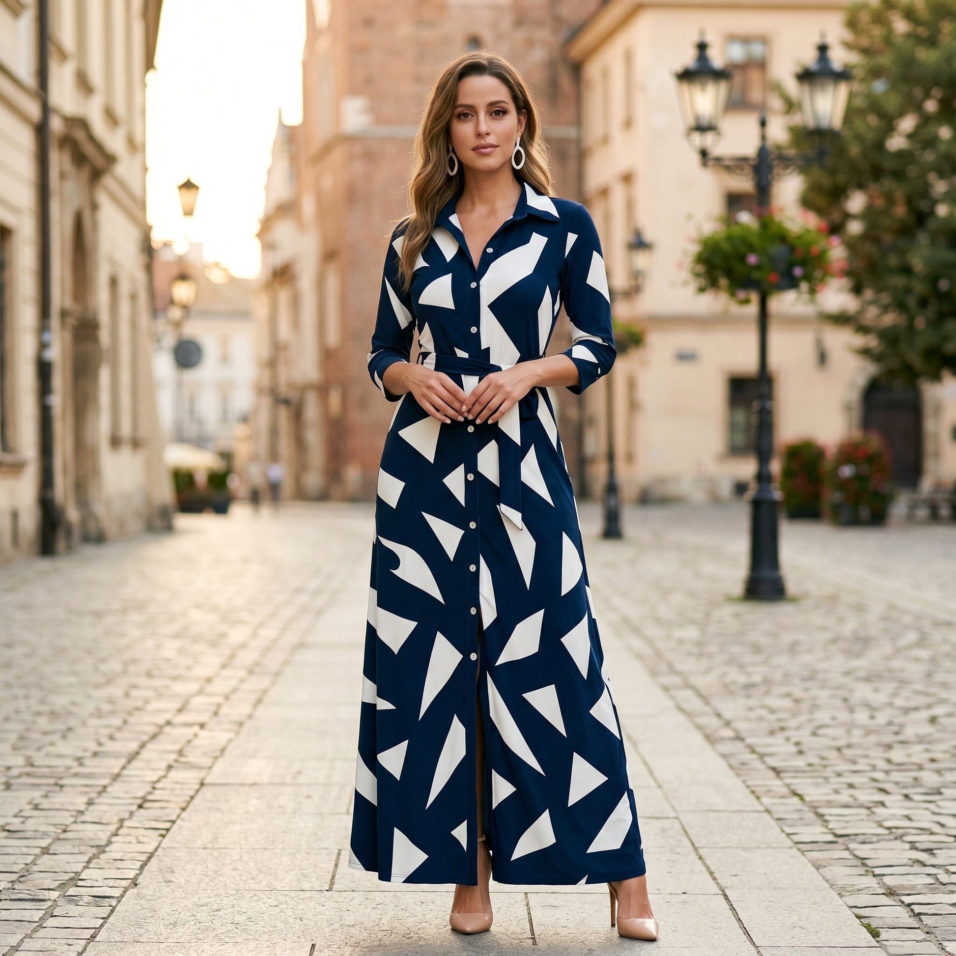 Black - A woman wearing a black and white vertically striped maxi shirt dress with a collar, three-quarter sleeves, and a self-tie belt at the waist, paired with black high-heeled sandals against a plain white background.
