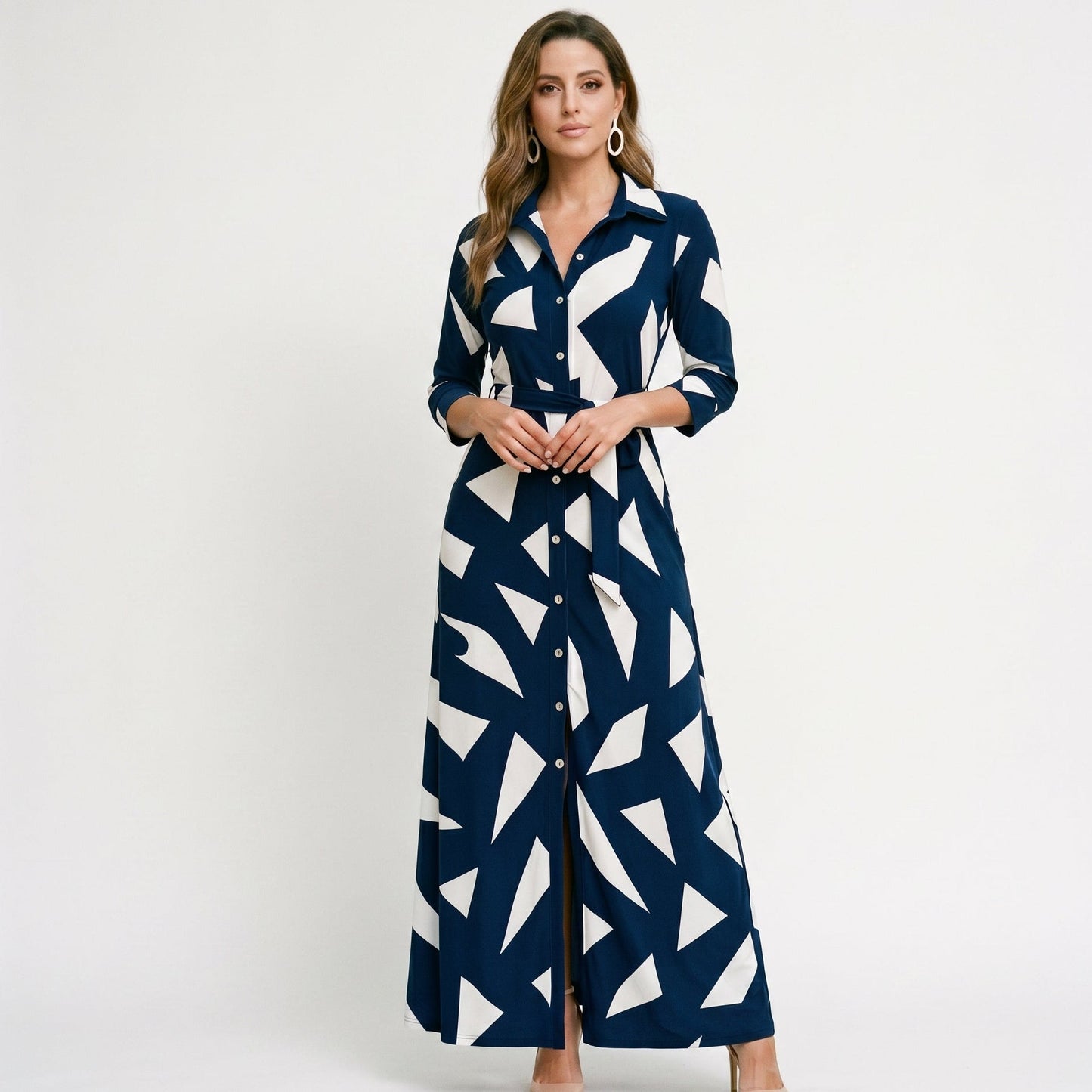 Navy - A woman wearing a black and white vertically striped maxi shirt dress with a collar, three-quarter sleeves, and a self-tie belt at the waist, paired with black high-heeled sandals against a plain white background.