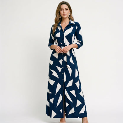 Navy - A woman wearing a black and white vertically striped maxi shirt dress with a collar, three-quarter sleeves, and a self-tie belt at the waist, paired with black high-heeled sandals against a plain white background.