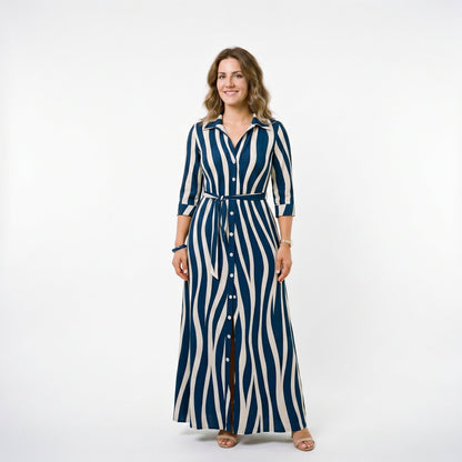 Blue - A woman wearing a black and white vertically striped maxi shirt dress with a collar, three-quarter sleeves, and a self-tie belt at the waist, paired with black high-heeled sandals against a plain white background.