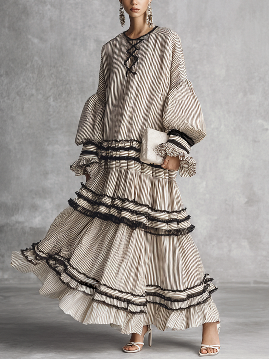 brown and white - A model wearing a voluminous, long-sleeved tiered maxi dress featuring vertical stripes, a lace-up neckline, balloon sleeves, and black ruffled trim along the tiers.