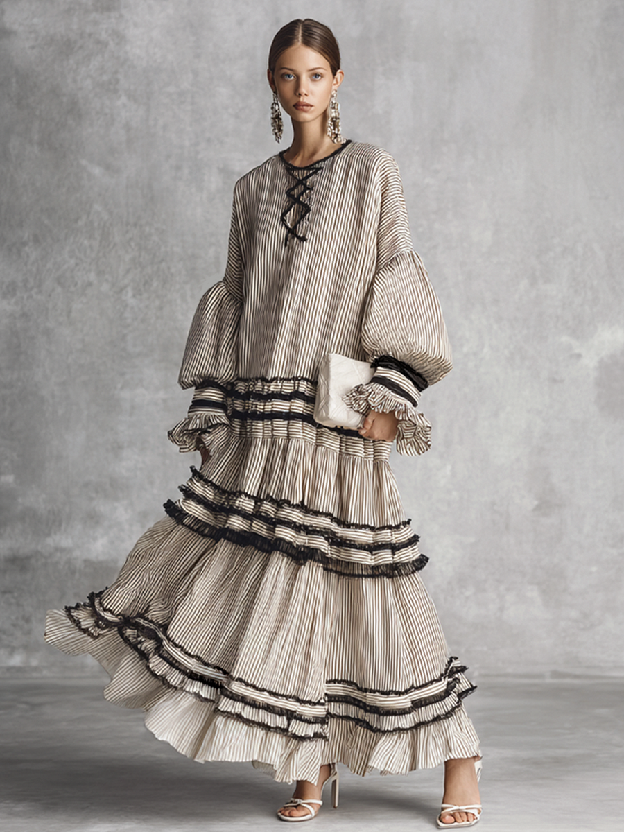 brown and white - A model wearing a voluminous, long-sleeved tiered maxi dress featuring vertical stripes, a lace-up neckline, balloon sleeves, and black ruffled trim along the tiers.