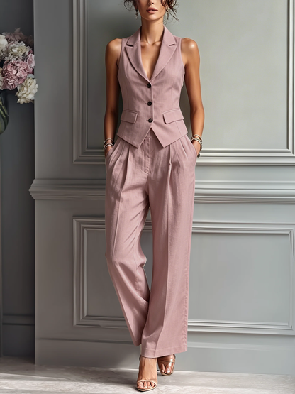 Blush Pink - A woman posing in a dusty pink tailored two-piece set featuring a sleeveless button-up waistcoat with lapels and matching high-waisted wide-leg trousers.