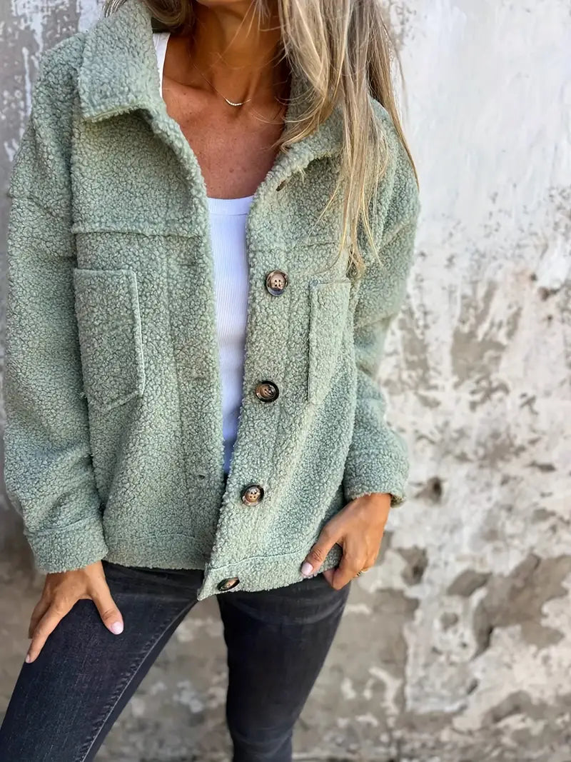 Green - A woman wearing a pink, textured teddy fleece shacket with large buttons and chest patch pockets, styled casually over a white top and dark jeans.