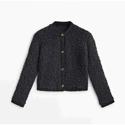 Black - A woman wearing a beige, textured boucle knit cardigan with a button-front closure, ribbed trims, and gold-tone buttons, styled casually over a white top and light blue jeans.