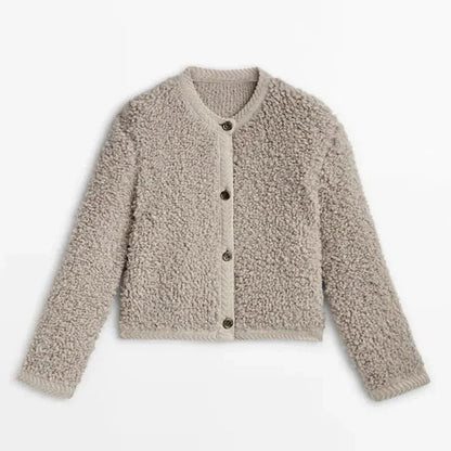 Khaki - A woman wearing a beige, textured boucle knit cardigan with a button-front closure, ribbed trims, and gold-tone buttons, styled casually over a white top and light blue jeans.