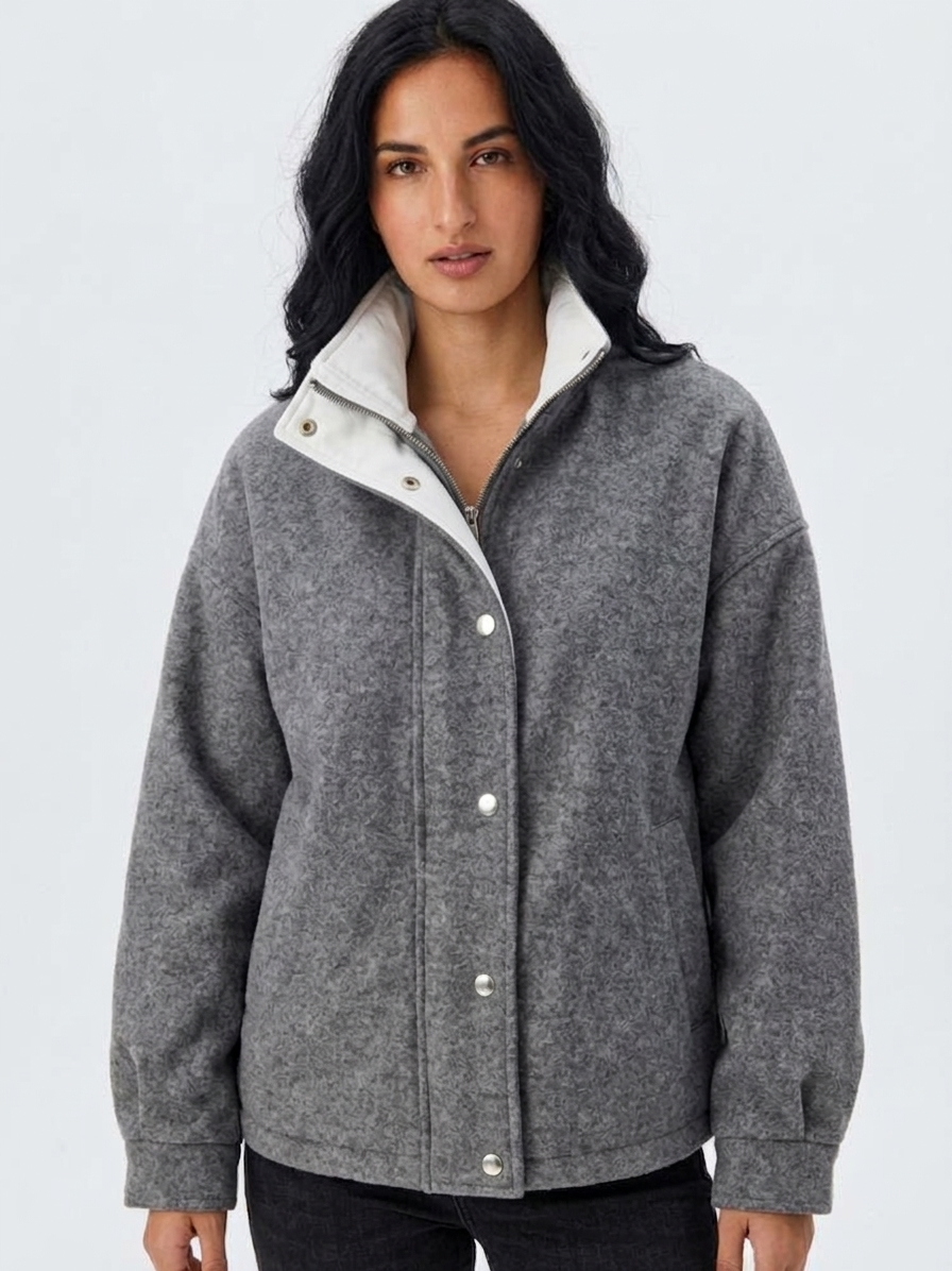 Gray - A woman wearing a dark navy blue textured jacket with a high stand collar lined in contrast cream fleece, featuring a snap-button front closure and a relaxed fit.