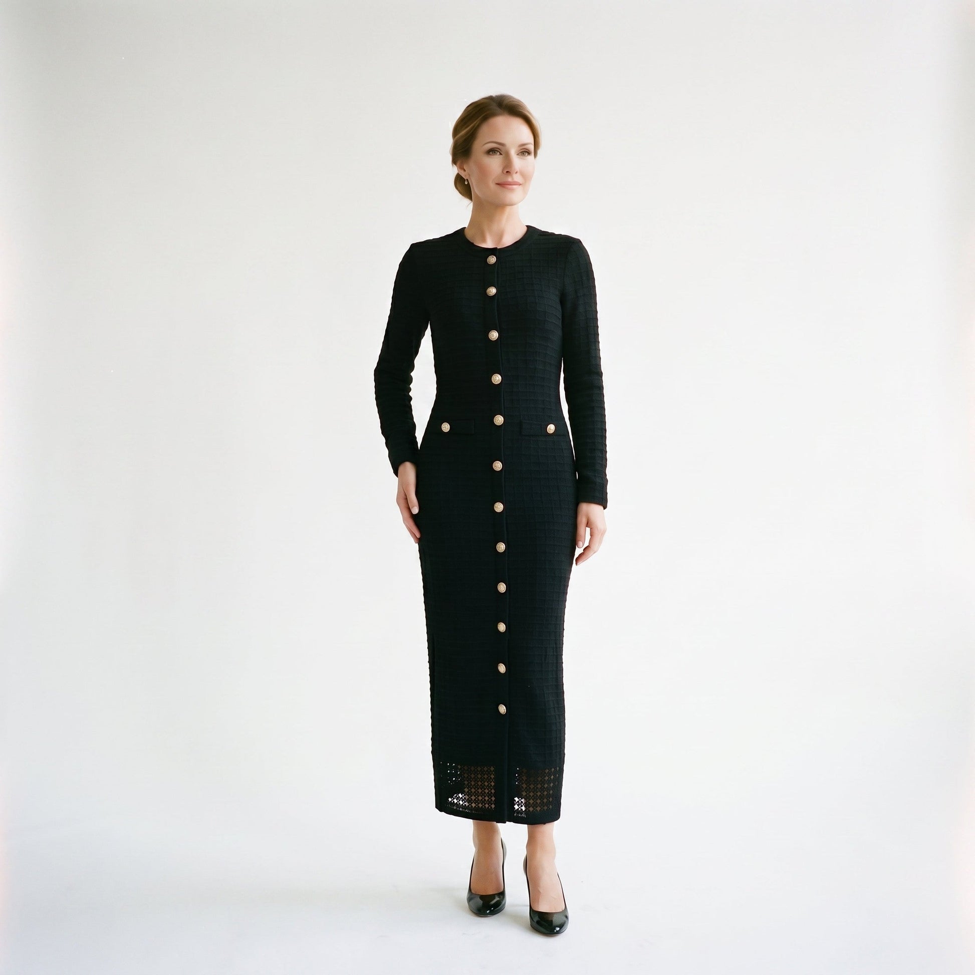 Black - A woman wearing a long-sleeve black textured knit column midi dress featuring gold-tone buttons down the front and a pointelle hem, set against a plain white background.