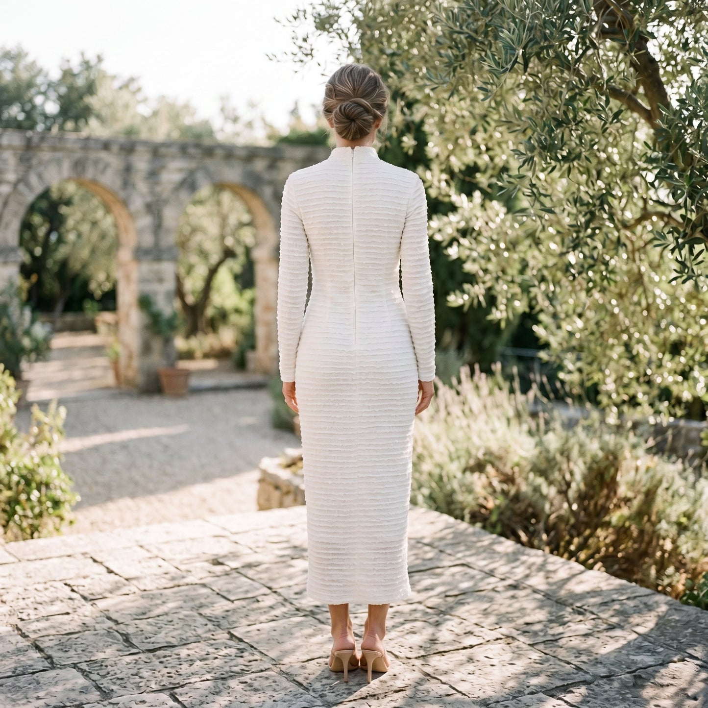Black - A woman wearing a long-sleeve black textured knit column midi dress featuring gold-tone buttons down the front and a pointelle hem, set against a plain white background.