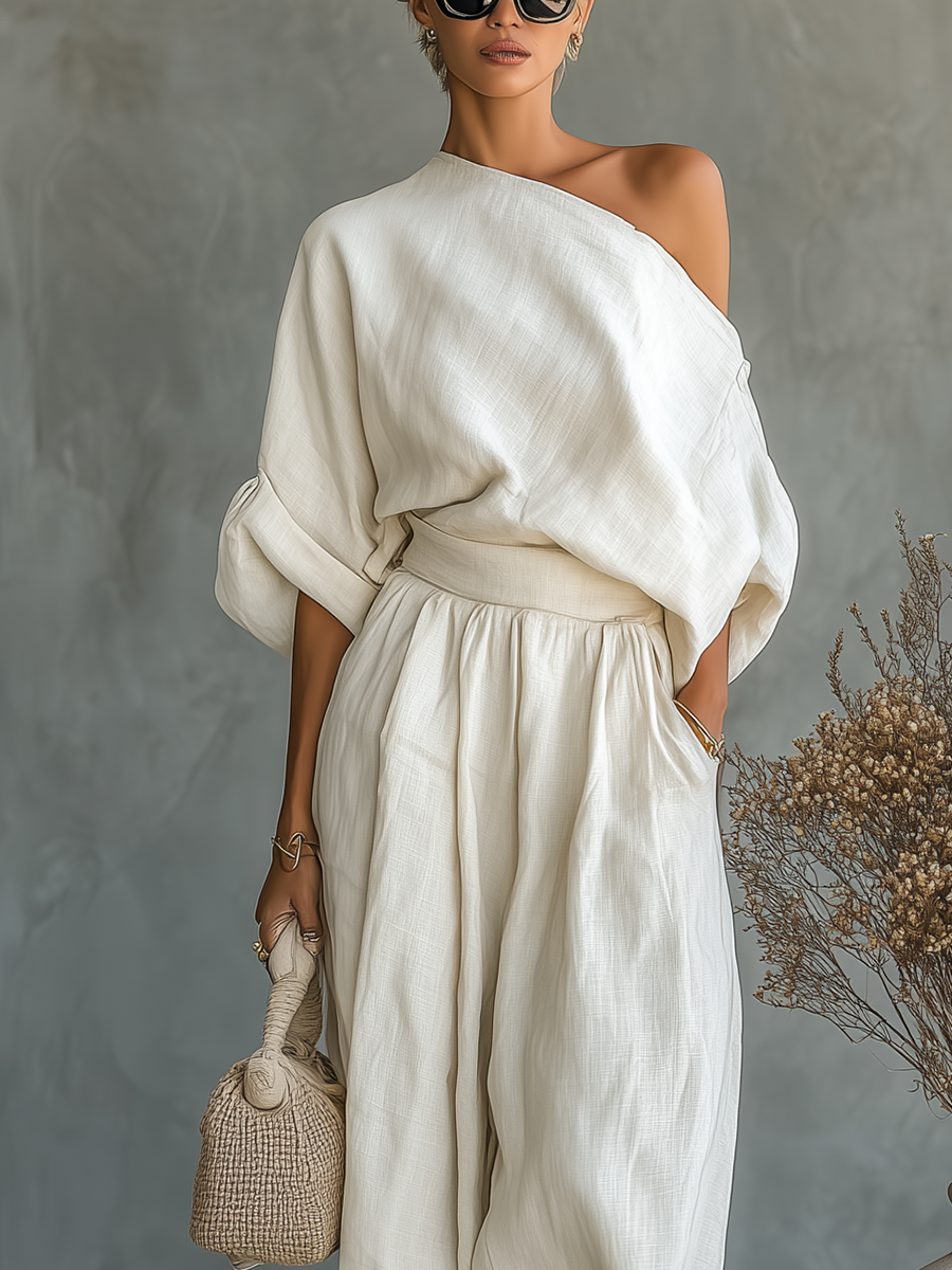 Off-white - A woman wearing an elegant cream-coloured, textured linen one-shoulder jumpsuit with a draped balloon sleeve, structured waistband, and voluminous tapered trousers.