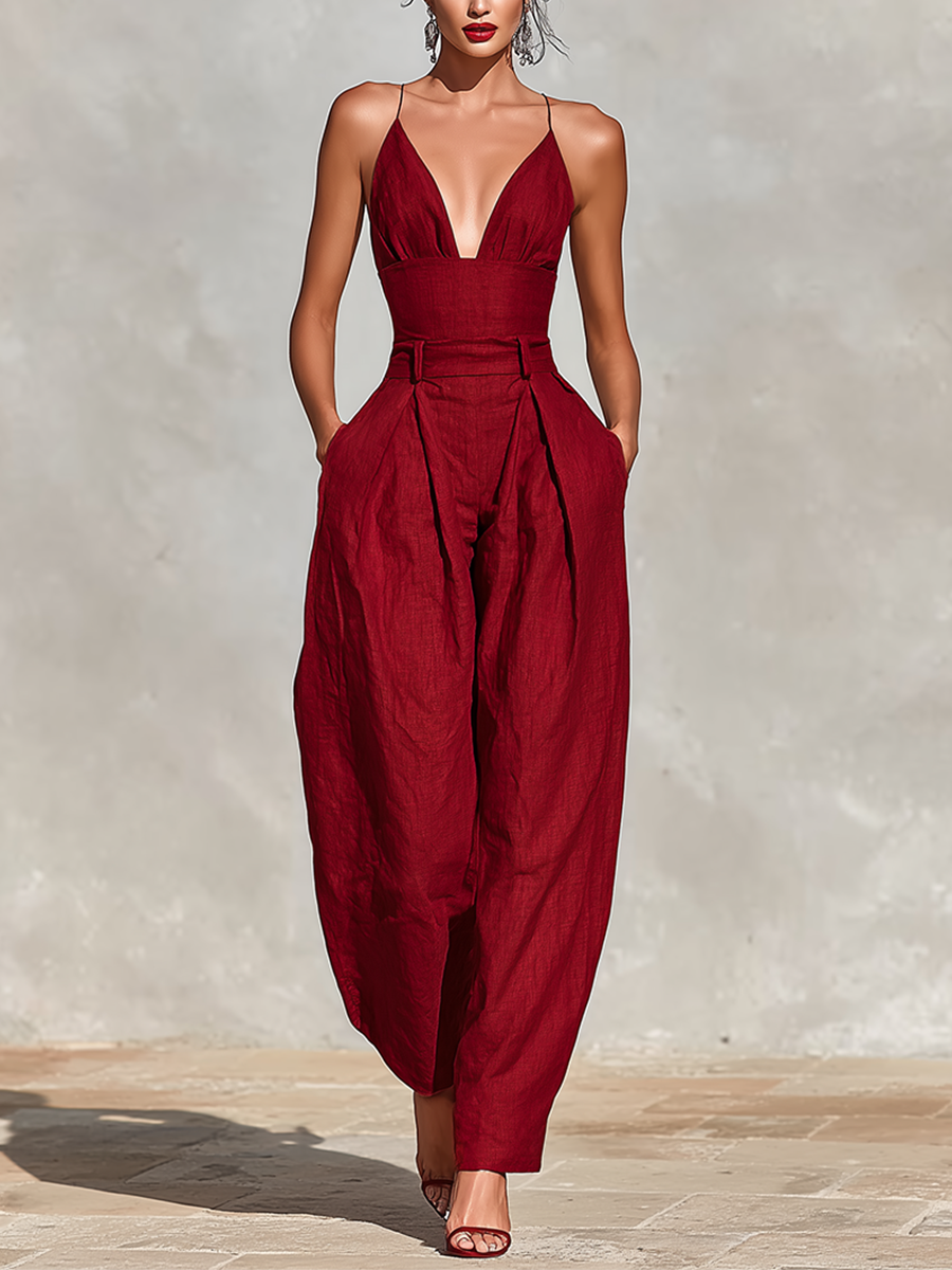 Red - A model wearing a deep red, textured linen wide-leg jumpsuit featuring a plunging V-neckline, structured high waist, and pleated trousers.