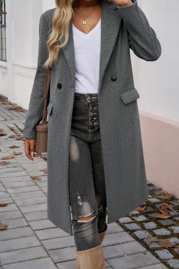Gray - A woman wearing a grey textured mid-length coat with notch lapels and flap pockets, styled over a white V-neck t-shirt and distressed grey jeans.