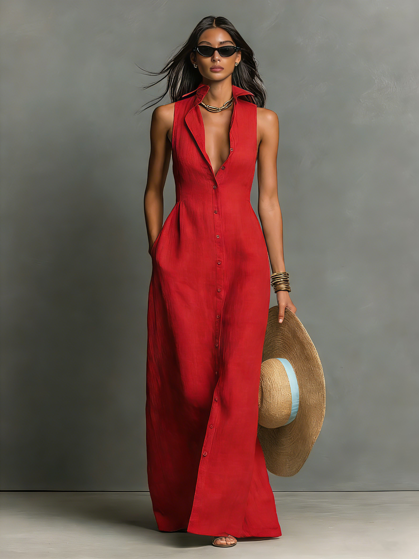 Black - A woman wearing a sleeveless red maxi dress with a point collar, button-down front, and side pockets, holding a wide-brimmed straw hat.