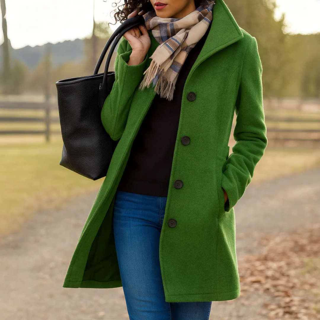 Green - A woman walking outdoors wearing a camel-coloured, mid-length textured coat with a stand collar and single-breasted button closure, styled with blue jeans and a scarf.