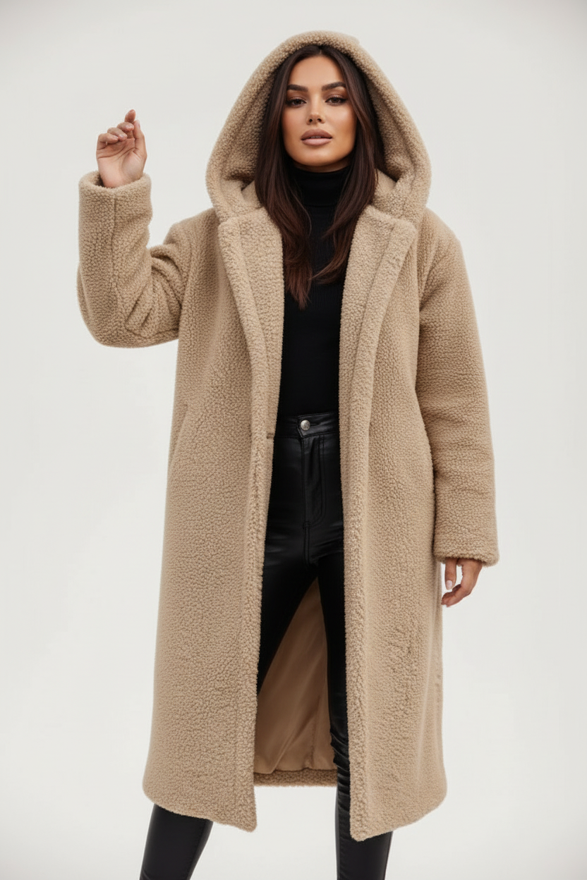 Beige - A woman wearing a mid-length olive green textured teddy coat with a large hood, styled over a black turtleneck sweater and black sunglasses against a plain white background.