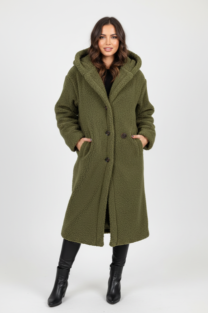 Green - A woman wearing a mid-length olive green textured teddy coat with a large hood, styled over a black turtleneck sweater and black sunglasses against a plain white background.