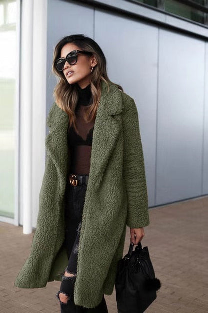 Army Green - A woman wearing a cream-coloured, longline textured teddy coat with oversized lapels, styled over a grey t-shirt and blue jeans.