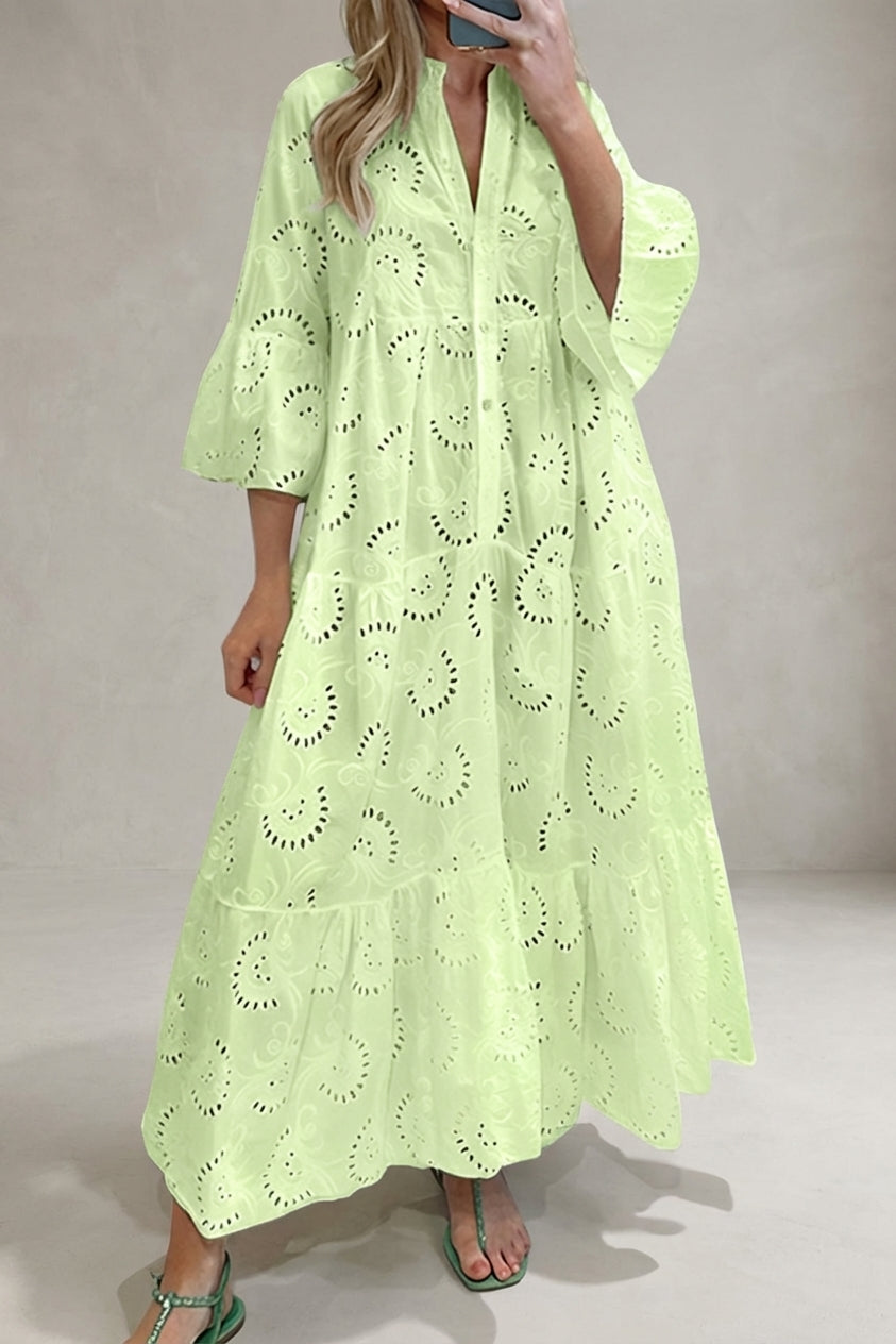 Yellow - A woman wearing a white, tiered broderie anglaise maxi dress with three-quarter bell sleeves, a split v-neckline, and a relaxed silhouette, paired with green flat sandals.